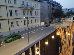 a green car parked on a street with buildings at Brand New Place in the City Centre in Žilina