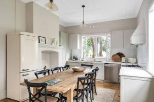 eine Küche mit einem Holztisch und Stühlen in der Unterkunft Luxury Heritage Home 10min Walk to Scenic World in Katoomba