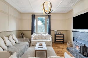 ein Wohnzimmer mit Couch und Kamin in der Unterkunft Luxury Heritage Home 10min Walk to Scenic World in Katoomba