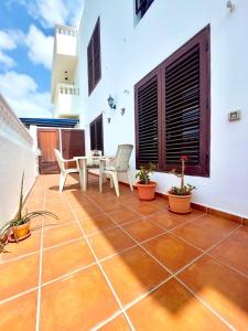 Un patio con una mesa y sillas en una casa. en Mar del norte, en Punta Mujeres