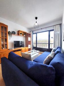 Una sala de estar con un sofá azul y una ventana grande. en Mar del norte, en Punta Mujeres 27 fotos más