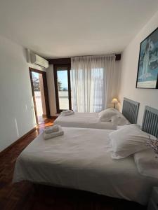 two white beds in a room with a window at Casa Vila Reyes in Sant Vicenç de Montalt