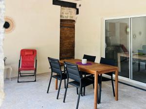 ein Esszimmer mit einem Holztisch und Stühlen in der Unterkunft La Ferme de Bournat in La Répara