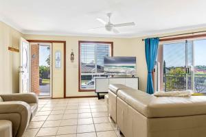 a living room with a couch and a flat screen tv at Coastal Delight In Shellcove in Dunmore