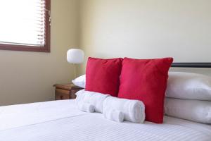 a bedroom with a red pillow on a bed at Coastal Delight In Shellcove in Dunmore