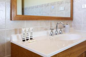 a bathroom with a sink and a mirror at Coastal Delight In Shellcove in Dunmore +18 photos