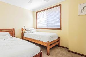 two beds in a room with a window at Coastal Delight In Shellcove in Dunmore