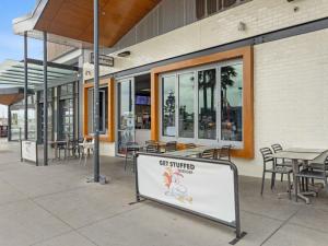a sign in front of a building with tables and chairs at Coastal Delight In Shellcove in Dunmore
