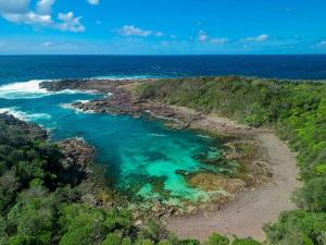 an aerial view of a beach with turquoise water at Coastal Delight In Shellcove in Dunmore