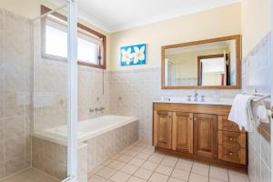 a bathroom with a tub and a sink and a shower at Coastal Delight In Shellcove in Dunmore