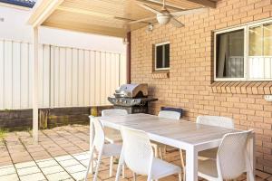 a white table and chairs on a patio with a grill at Coastal Delight In Shellcove in Dunmore