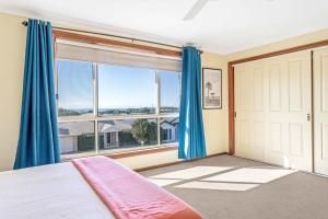 a bedroom with a bed and a large window at Coastal Delight In Shellcove in Dunmore