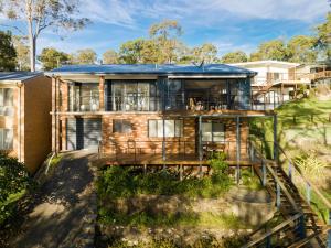 a house with a blue roof at Waterfront Treetops Getaway in Wangi Wangi