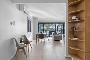 a living room with a table and chairs at Waterfront Treetops Getaway in Wangi Wangi
