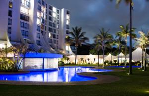 a swimming pool in front of a building at night at Beachbreak Holiday Letting in Durban