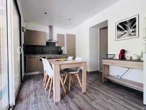 eine Küche mit einem Holztisch und weißen Stühlen in der Unterkunft La Ferme de Bournat in La Répara + 32 Fotos