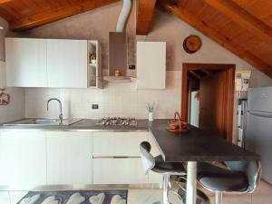 Una cocina con gabinetes blancos y una encimera negra. en S&M APARTMENTS - Splendida Mansarda in Legno Nova Milanese - Monza, en Nova Milanese