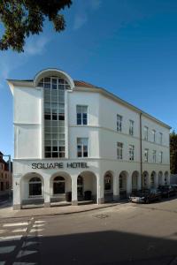 - un bâtiment blanc avec un hôtel sauber en face dans l'établissement Square Hotel, à Courtrai