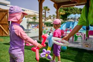 two little girls playing with toys at a park at Blue Sea Beach Resort in Faliraki