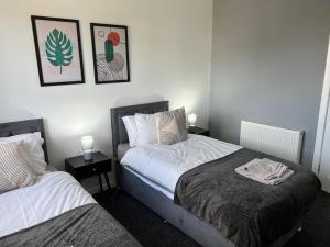 a bedroom with two beds and two lamps and pictures on the wall at Charming, Modern Flat sleeps 5 in Tayport