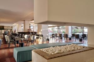 a lobby with a bar with chairs and tables at Blue Sea Beach Resort in Faliraki