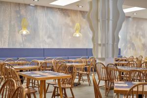 a dining room with wooden tables and chairs at Blue Sea Beach Resort in Faliraki