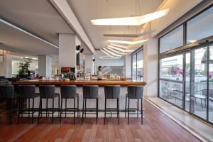 a bar in a restaurant with stools around it at Blue Sea Beach Resort in Faliraki