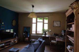 a living room with a couch and a table and a window at L’hors-du temps in Le Tartre +15 photos