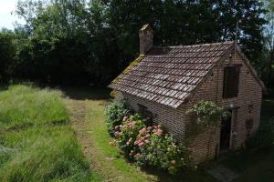 a brick house with flowers in front of it at L’hors-du temps in Le Tartre