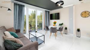 Televízia a/alebo spoločenská miestnosť v ubytovaní Wonder Home - Apartamenty w malowniczej okolicy, z balkonami i widokiem na góry