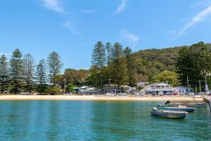 two boats in the water near a beach at Umina Myrtle Bungalow Sleeping 4 Guests in Blackwall