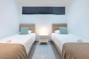 two beds sitting next to each other in a room at Benalmádena Puerto Marina Vacation Apartment 1 minute from the beach in Benalmadena Costa