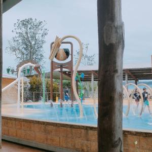 un parc aquatique avec une fontaine et une chaise dedans dans l'établissement Driftwood Cottage Your Coastal Haven, à Lemon Tree Passage
