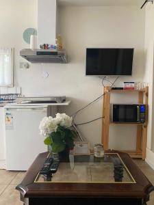 sala de estar con mesa, TV y flores en La Luna - Denise, en Heerhugowaard