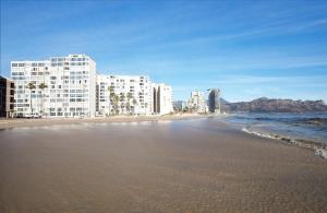 Una vista de una playa con edificios y el océano. en Seaside Sunsets, en Strand