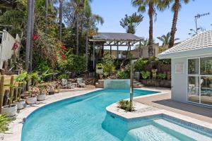 a swimming pool in a backyard with a gazebo at Exquisite Beachside Luxury Resort Style Pool in Wamberal North