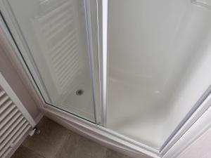 a shower with a glass door in a bathroom at R&R Coastal Retreats Cedars 63 in Skegness
