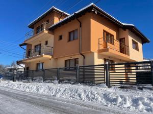 a house with a fence in the snow at Villa Stoyanovata Kashta in Samokov