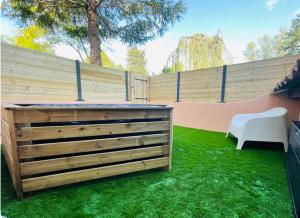 un patio trasero con una valla de madera y césped verde en aixclusive, en Le Tholonet