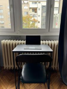a laptop computer sitting on a table in front of a window at Apartment Silver Pedestrian Zone in Belgrade