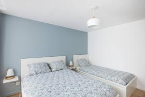 a bedroom with a bed with blue walls at Le Grimont - 5 min de DisneyLand Paris in Coupvray