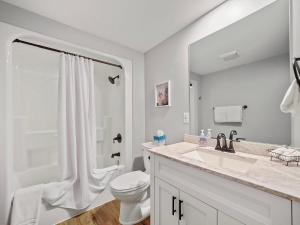 a white bathroom with a toilet and a sink at 658 Disciples Village Condo in Boyne Falls +29 photos