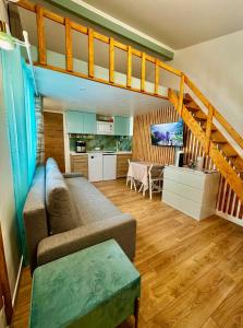 Una sala de estar con un sofá y una cocina. en Canarias Bungalow, en Saint-Jeannet