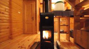 a wood stove in a room in a cabin at Chalets Zelena Vrata in Fužine