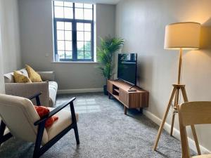 a living room with a couch and a television at Chic Mill conversion beside Piece Hall & Eureka! in Halifax