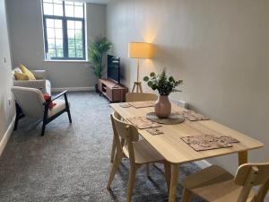 a living room with a wooden table and chairs at Chic Mill conversion beside Piece Hall & Eureka! in Halifax