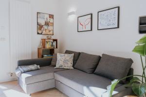 a living room with a gray couch in a room at Lake House in Nago-Torbole