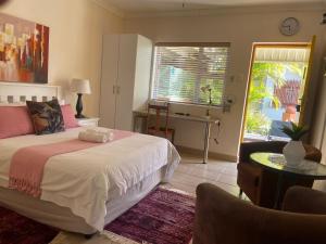 a bedroom with a bed and a table and a desk at @47 Guest House in Gqeberha +60 photos