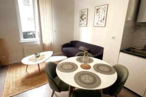 a living room with a white table and chairs at Charmant appartement Près de la Gare in Saint-Quentin