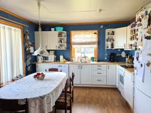a kitchen with a table and a white refrigerator at Comfortable house with balcony&Terrace and view in Kopervik